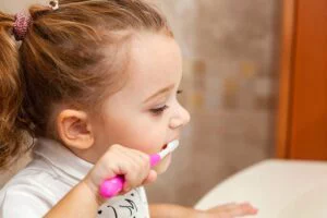 little girl brushing her teeth