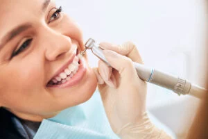 woman smiling while having her teeth cleaned