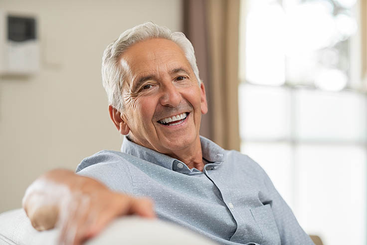 senior man with dentures smiling