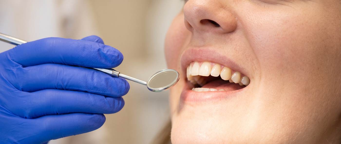 Dental checkup: mirror held to a patient's healthy smile