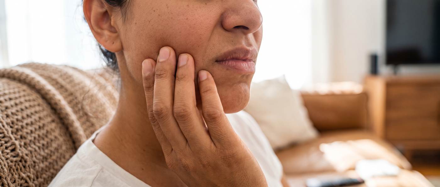 A person holding their jaw with tooth pain